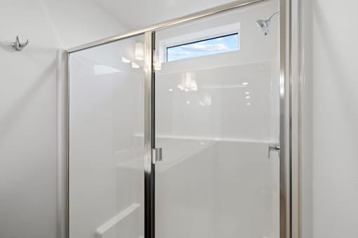 Glass door with a handle and a window in the background.