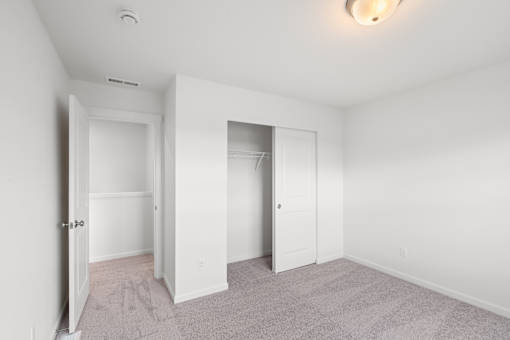 A white room with a carpeted floor and two doors.