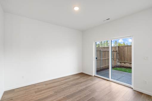 A room with a sliding glass door leading to a backyard.
