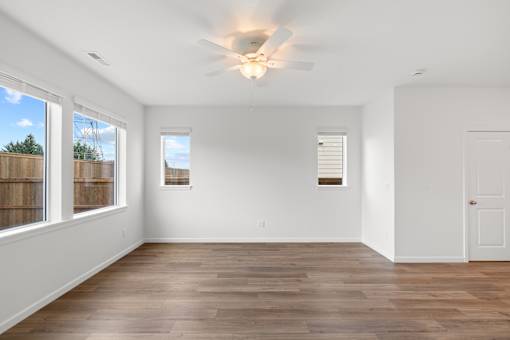 A room with wooden floors and a ceiling fan.