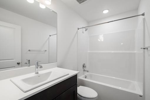 A white sink with a silver faucet is on a countertop in a bathroom.