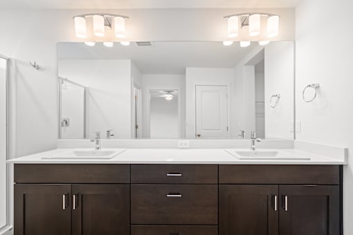 A bathroom with a white countertop and brown cabinets.