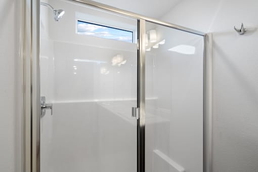 A glass door with a handle and a window in the background.