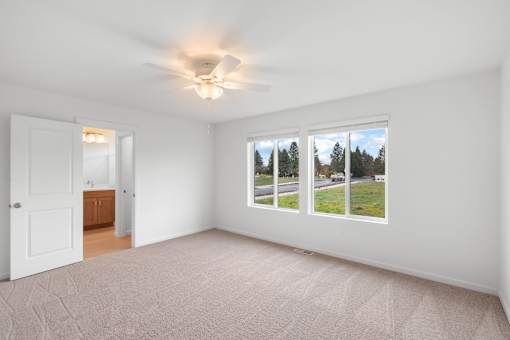Room with a ceiling fan and carpeted floor.