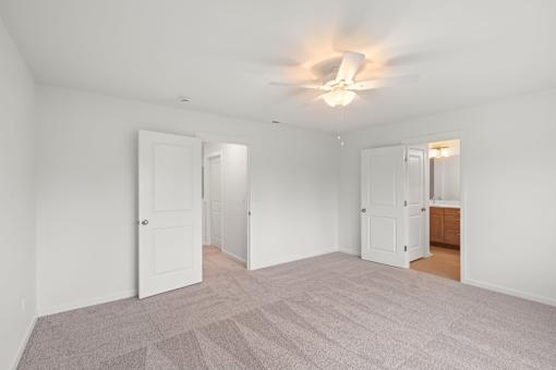 Room with a ceiling fan and carpeted floor.