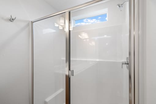 White bathroom with a glass shower door.
