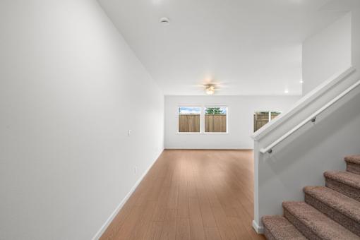 Hallway with wooden floors and a staircase.