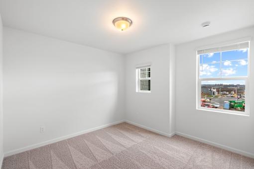 Room with a window and a view of a cityscape outside.