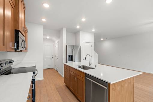 A modern kitchen with wooden cabinets and white countertops.
