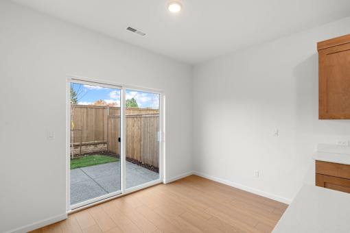 Room with a sliding glass door leading to a backyard.