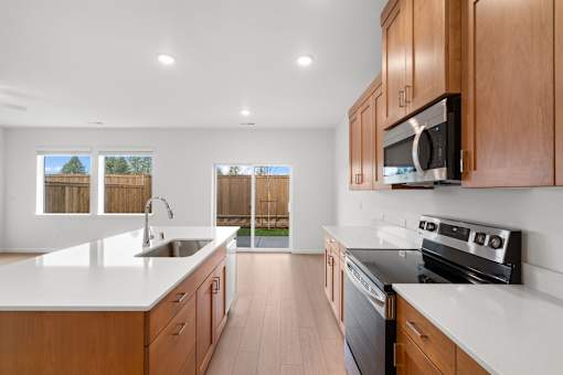 Modern kitchen with wooden cabinets and stainless steel appliances.