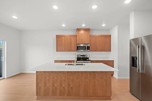 Kitchen with wooden cabinets and a stainless steel refrigerator.