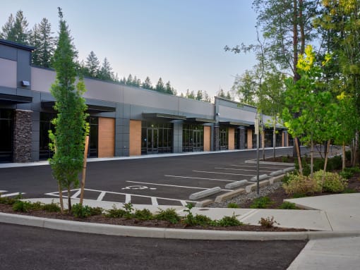 a parking lot in front of a building with trees