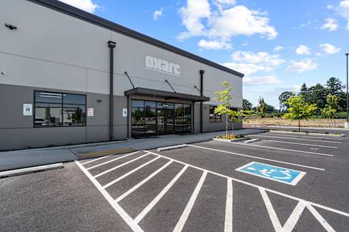 A parking lot in front of a building with a sign that says "OXC".