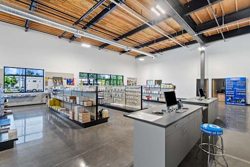 A store with a variety of products on display and a counter with a computer.