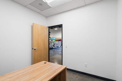A room with a wooden table and a door leading to a hallway.