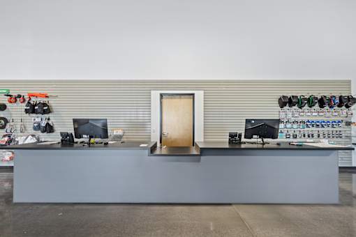 A grey reception desk with a computer monitor and a door in the middle.
