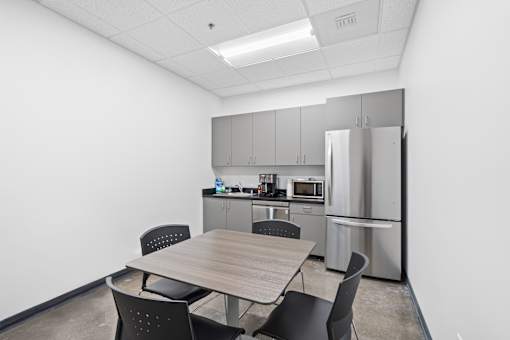 A kitchen area with a table and chairs.