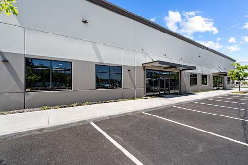 A large white building with a parking lot in front.