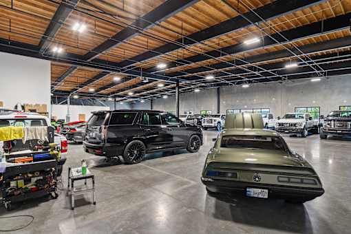 A car show with a green car in the spotlight.