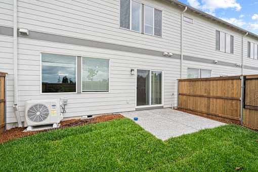 A house with a white siding and a brown fence.