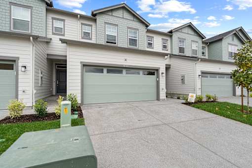 A row of houses with garages and driveways.