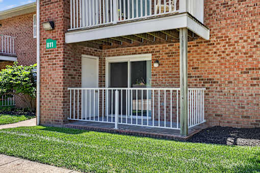 A red brick building with a balcony and a green sign with the number 811.