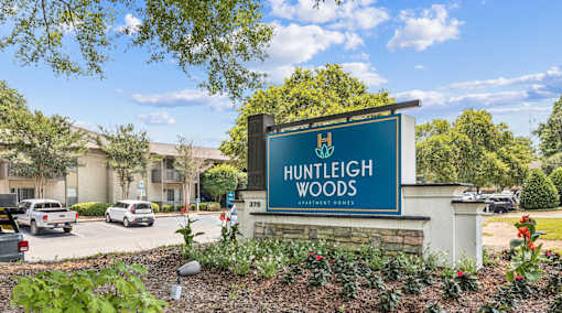 A sign for Huntleigh Woods is shown in front of a building.