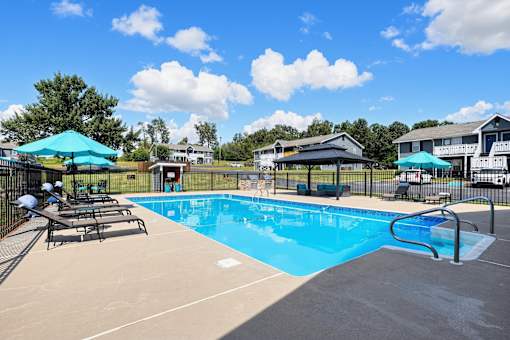 A large outdoor swimming pool with a slide and sun loungers.