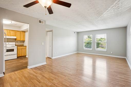 A room with a ceiling fan and wooden flooring.