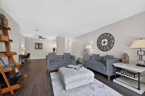 Living room at Renaissance at Carol Stream featuring a grey couch, white coffee table.