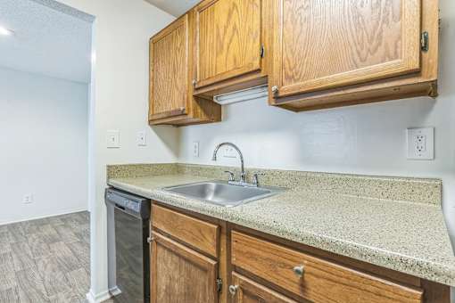 Kitchen with wood cabinets and granite counters at Ashford Place Mobile AL