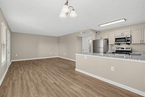 A kitchen area with a refrigerator, microwave, and oven.