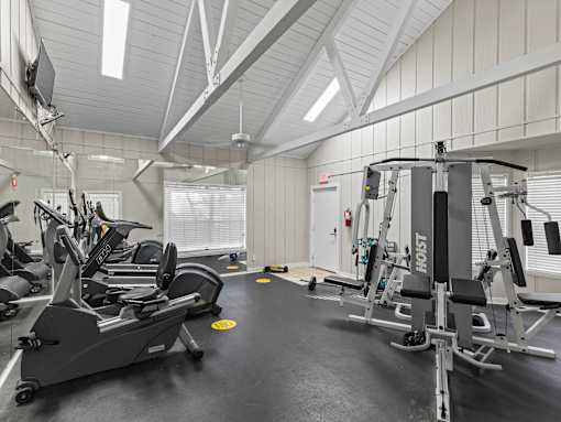 A gym with treadmills, elliptical machines, and weight machines.