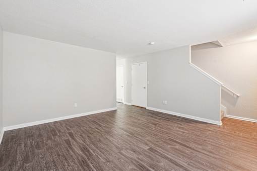 A room with wooden flooring and white walls.
