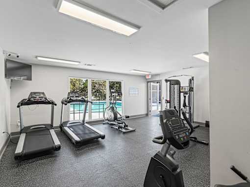 A gym with treadmills, exercise bikes, and other equipment.