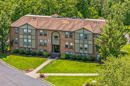A large brick house with a green lawn in front.