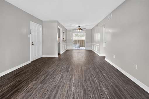 A long hallway with wood floors and white walls.