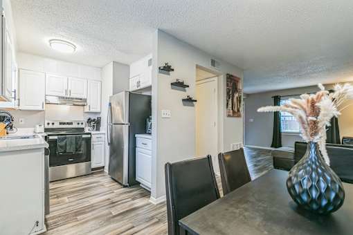 A kitchen with a refrigerator, oven, and sink.