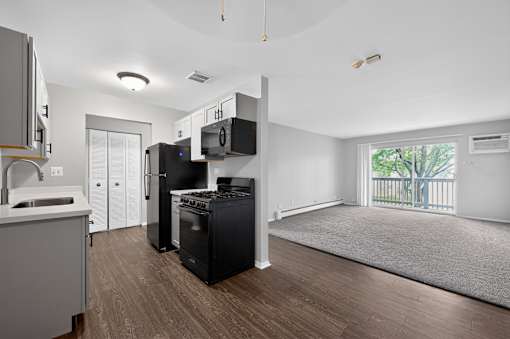 Kitchen at Renaissance at Carol Stream featuring a black stovetop oven and black microwave in Carol Stream, IL.