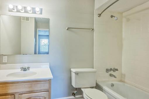 A white bathroom with a sink, toilet, and bathtub.