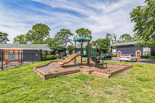 A playground with a slide and a green canopy structure.