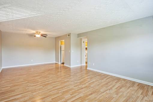 A room with wooden floors and a ceiling fan.