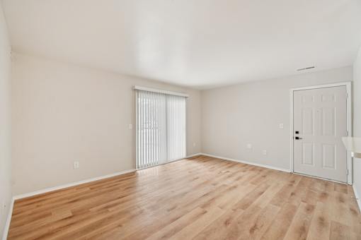 A room with wooden flooring and a white door.