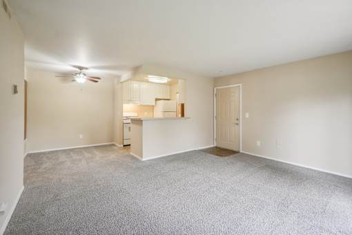 Empty room with a ceiling fan and carpeted floor.