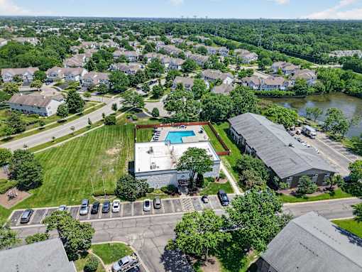 Aerial view of the Renaissance at Carol Stream community featuring homes, a swimming pool, and a parking lot in Carol Stream, IL.