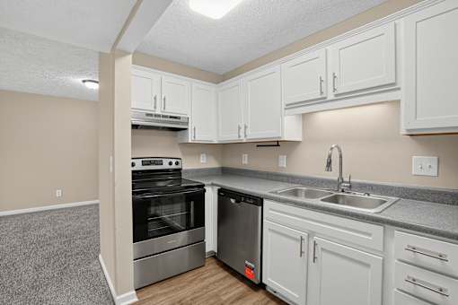 A kitchen with white cabinets and a stainless steel dishwasher.