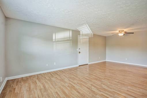 A room with wooden flooring and a ceiling fan.