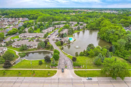 A bird's eye view of a residential area with a lake and greenery.