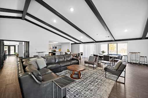 A modern living room with a black leather couch and a wooden coffee table.